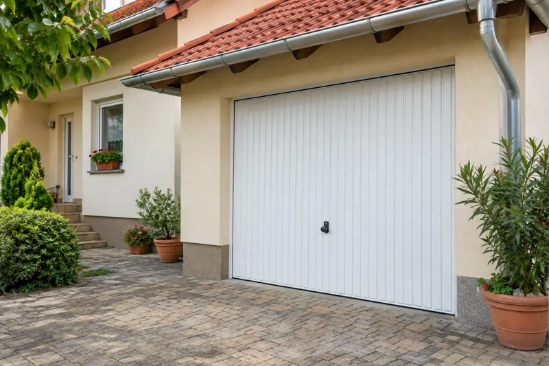 White up-and-over garage door with vertical ribs, closed, on a family house